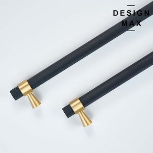 Textured black bars serving as appliance pulls, secured by round gold brass bases and capped with cylindrical gold brass ends. 